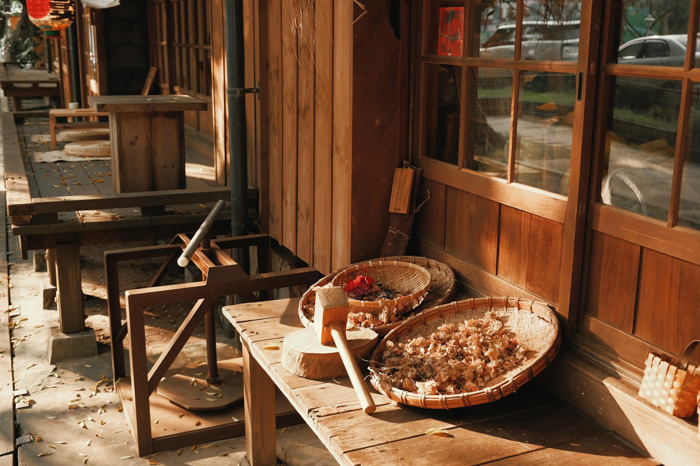 Outils de menuiserie traditionnels et paniers de copeaux sur le porche d'un atelier.